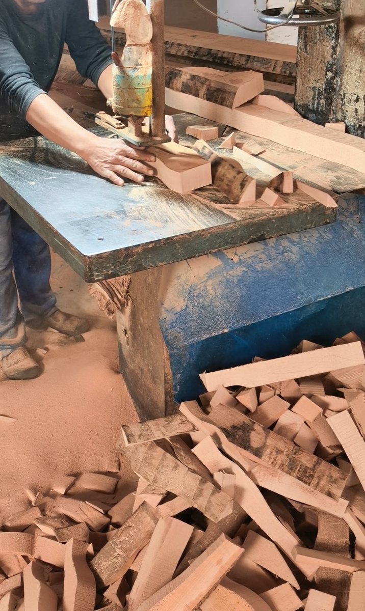 Manual band-saw cutting follows the marked profile.